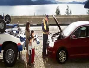 a famliy stuck in a highwasy getting help from a professional checking the family's car engine