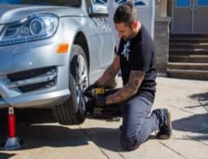 a man changing tires for roadside assitacne and towing service